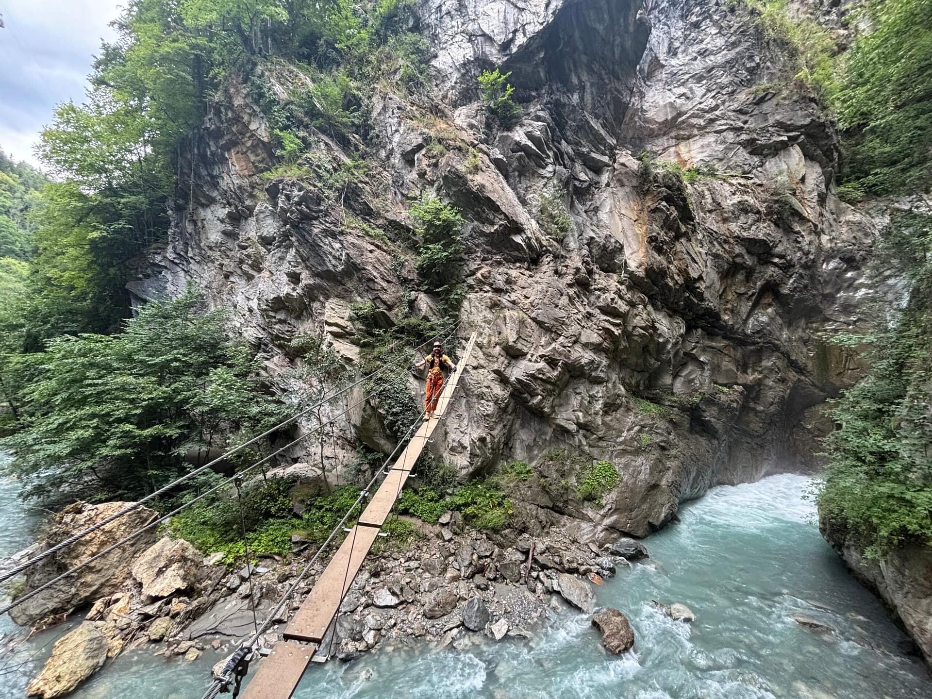 Woman crossing a suspension bridge in Via Ferrata du Parc Thermal, France