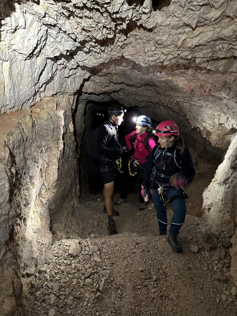 Via Ferrata de Luca – Innerkofler maršruto tuneliuose stovintys žmonės su šalmais ir ciklopais