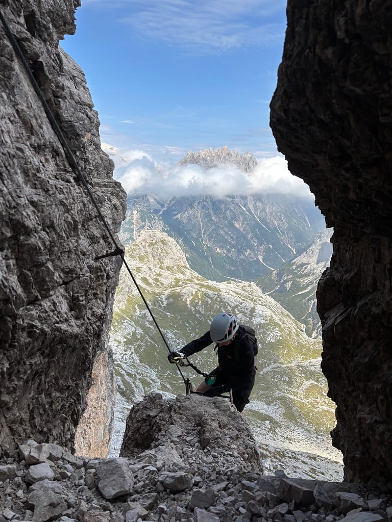 Woman climbing the via ferrata delle Scallette on the Torre di Toblin towers, Italian Dolomites