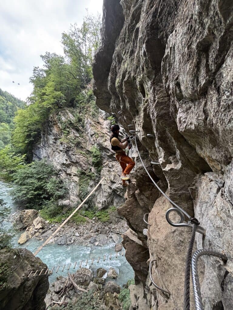 Vyras lipantis kopėtėlėmis via ferrate maršrute