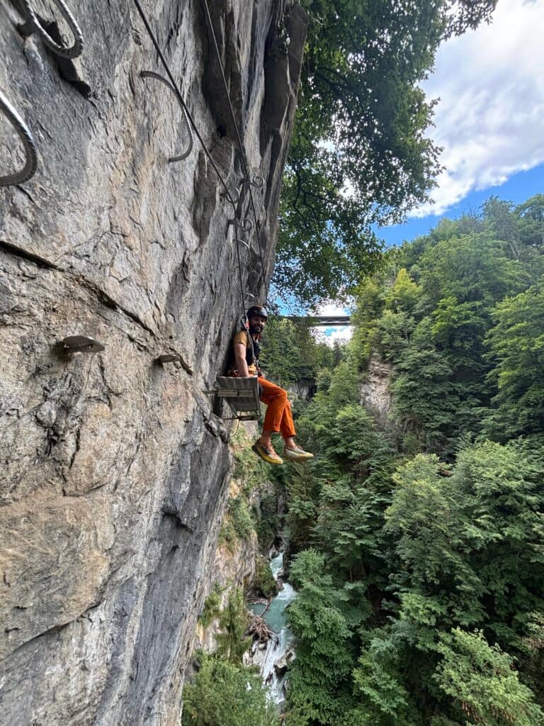 Vyras sėdi ant platformos via ferratos maršrute